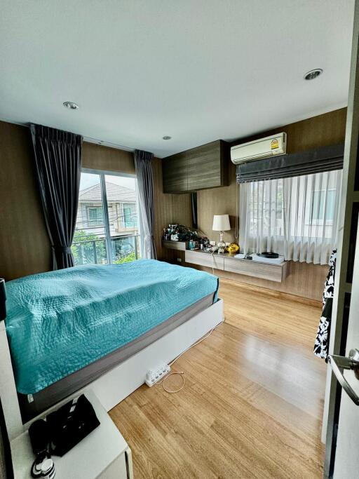 Modern bedroom with large windows and wooden flooring