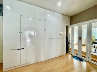 Spacious bedroom with built-in white wardrobe and mirrored sliding doors