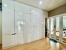 Spacious bedroom with built-in white wardrobe and mirrored sliding doors