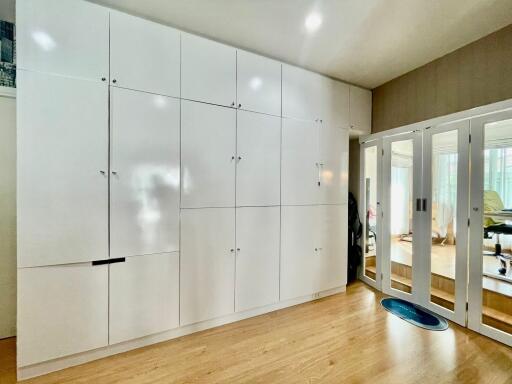 Spacious bedroom with built-in white wardrobe and mirrored sliding doors