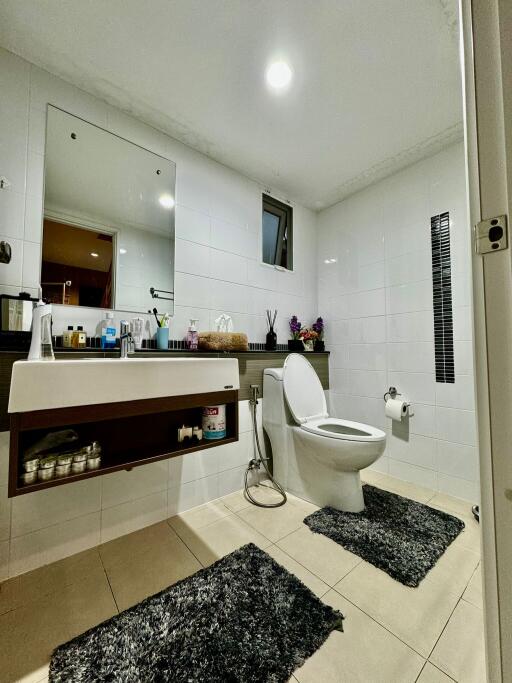 Modern bathroom with sink, toilet, mirror, and shelving