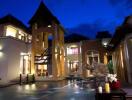 Exterior view of a luxurious outdoor area with a pool, traditional architecture, and a decorative elephant fountain