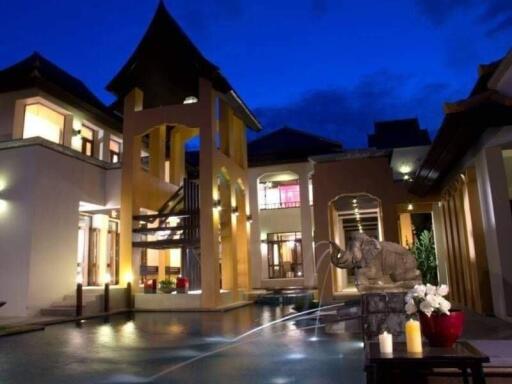 Exterior view of a luxurious outdoor area with a pool, traditional architecture, and a decorative elephant fountain