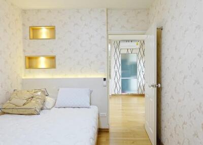 Modern bedroom with decorative wall niches and access to hallway