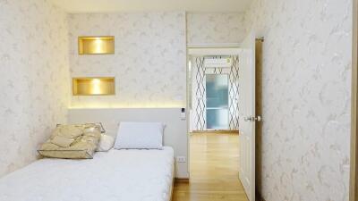 Modern bedroom with decorative wall niches and access to hallway