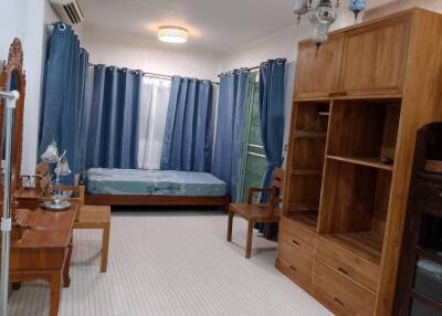 Bedroom with wooden furniture, bed, and blue curtains