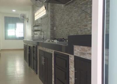 Modern kitchen with sleek dark cabinets and stone backsplash