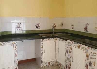 Kitchen with yellow walls, white cabinets, and decorative tile backsplash