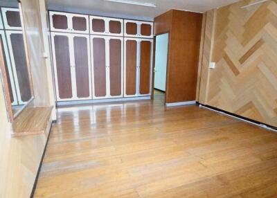 Spacious bedroom with hardwood floors and built-in closets