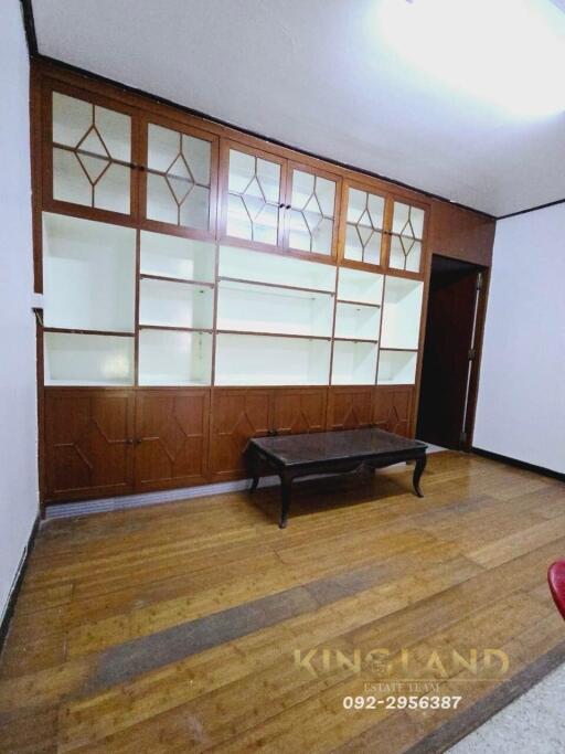 Living room with wood paneling and built-in shelves