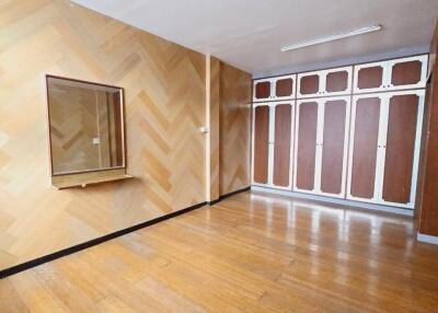 Spacious bedroom with wooden floors and built-in wardrobes