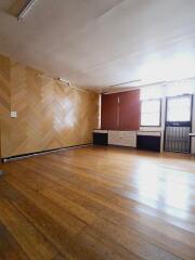 Spacious living room with wooden flooring and large windows