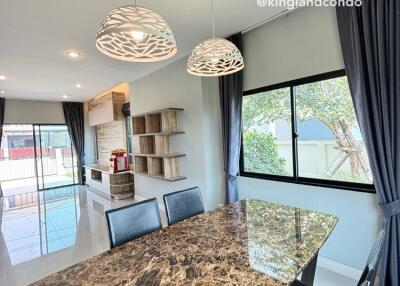 Marble dining table in a bright dining area with chandelier lighting and large windows