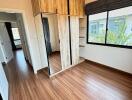 Bedroom with wooden flooring and a wardrobe with mirrored door