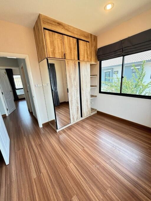 Bedroom with wooden flooring and a wardrobe with mirrored door