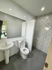 Modern bathroom with toilet, sink, and shower area