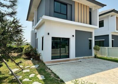 Two-story modern house exterior with a front yard and driveway