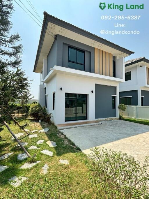 Two-story modern house exterior with a front yard and driveway