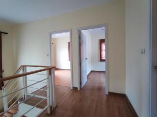 Hallway with wooden floor and doors leading to other rooms