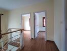 Hallway with wooden floor and doors leading to other rooms