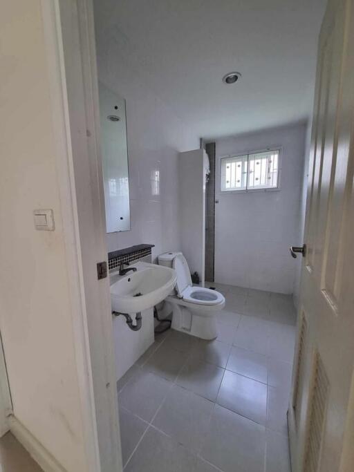 Modern bathroom with white fixtures and tiled flooring