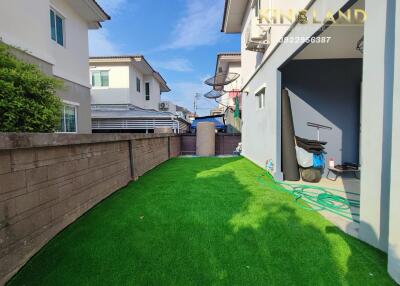 Backyard with green lawn and neighboring houses