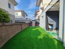 Backyard with green lawn and neighboring houses