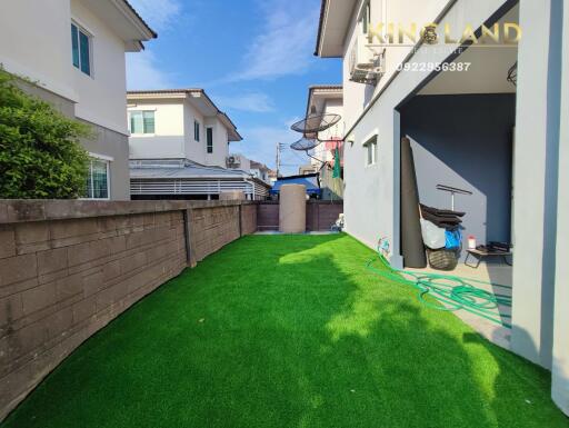 Backyard with green lawn and neighboring houses