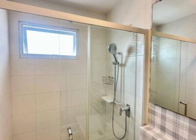 Modern bathroom with glass shower enclosure and wall-mounted shower head