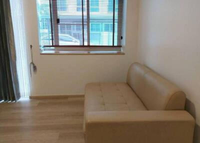 Minimalistic living area with beige sofa and large window