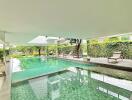 Indoor swimming pool with seating area and greenery view