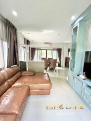 Spacious living room with leather sofa and dining area