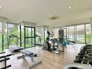 Modern gym with various exercise equipment and large windows