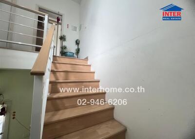 Staircase with wooden steps and white railings