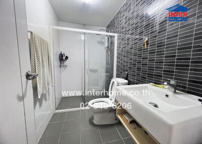 Modern bathroom with shower, sink, and toilet