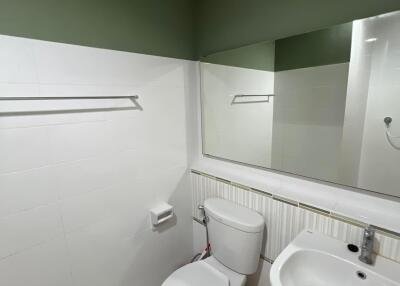 Modern bathroom with sink, toilet, and large mirror