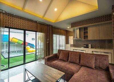 Living area with a sectional sofa, large windows, and a view of the outdoor playground