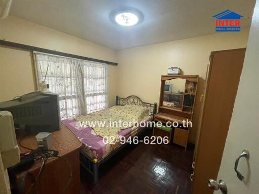 Bedroom with bed, wooden furniture, and window