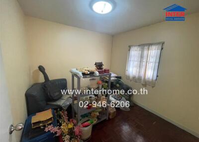 Small cluttered bedroom with shelves and window