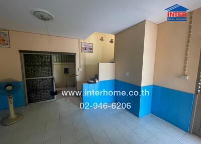 Living area with tiled floor, phone number displayed, and partition walls