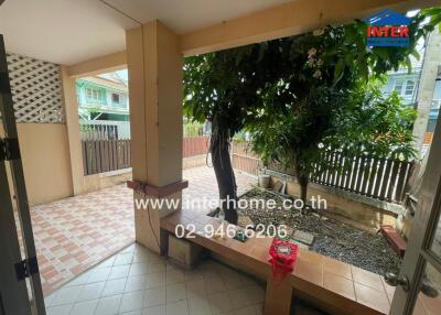 Spacious patio area with tiled flooring and greenery