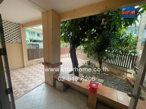 Spacious patio area with tiled flooring and greenery