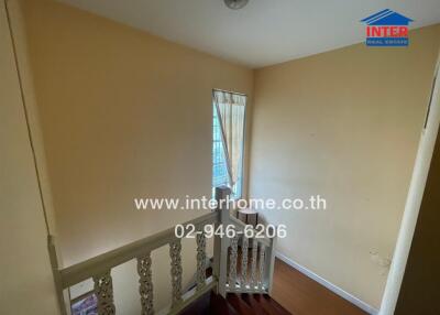 Staircase with beige walls and white railing