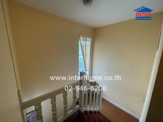 Staircase with beige walls and white railing