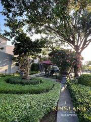 Manicured garden with statue, trees and outdoor seating area