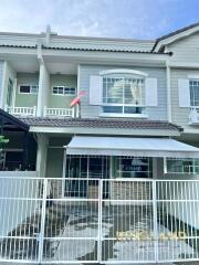 Front view of a two-story residential building with a gated entrance