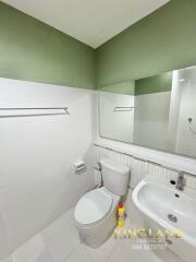 Modern bathroom with white fixtures and green walls