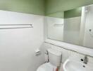 Modern bathroom with white fixtures and green walls