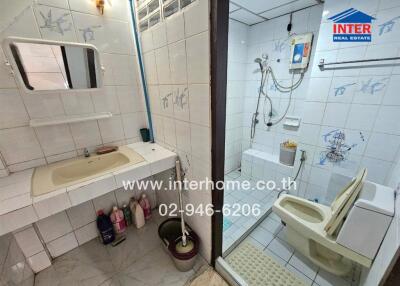 Clean and compact bathroom with beige fixtures and shower enclosure