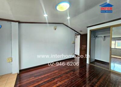 Empty bedroom with wooden floors and mirrored wardrobe